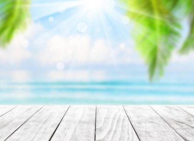 Bulanık mavi gökyüzü ve deniz Bokeh ışığı ve hindistan cevizi palmiyesi yapraklarıyla. Tropik yaz manzarası. Yaz tatili kavramı.