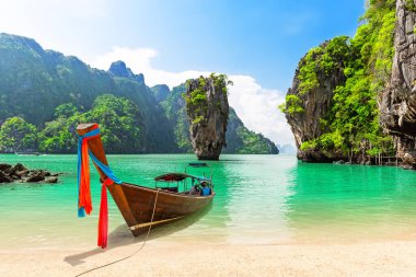 Tayland 'ın Phuket yakınlarındaki ünlü James Bond adası. Tayland 'ın Phang Nga Körfezi' nde geleneksel ahşap kuyruklu teknesi ve güzel kumsallı James Bond adasının seyahat fotoğrafı..