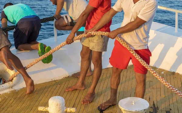 Man pulling rope on boat