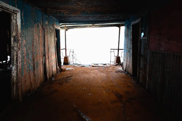 Sonunda ışık ile terk edilmiş paslı bir koridor — Stok fotoğraf