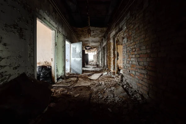 Abandoned corridor in damaged building — Stock Photo, Image