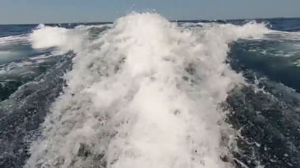 Разбрызгивание воды с моторной лодки на заднем плане — стоковое видео