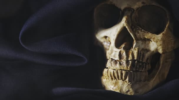 Primeros planos de una vieja calavera cubierta de una túnica negra — Vídeos de Stock