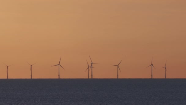 Ветряные турбины в море на закате — стоковое видео