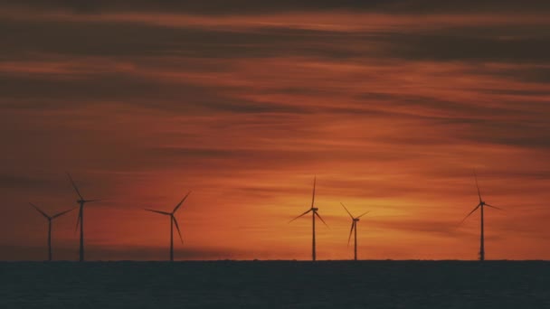 Turbinas eólicas no mar sob o pôr do sol — Vídeo de Stock