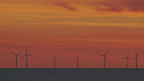 Turbinas eólicas no mar sob o pôr do sol — Vídeo de Stock
