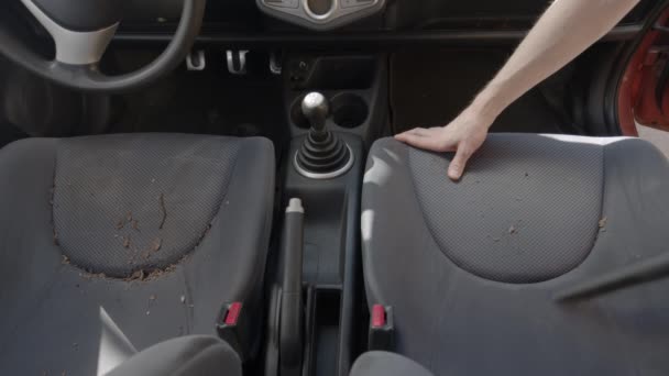 Мужчина чистит салон грязной машины пылесосом — стоковое видео