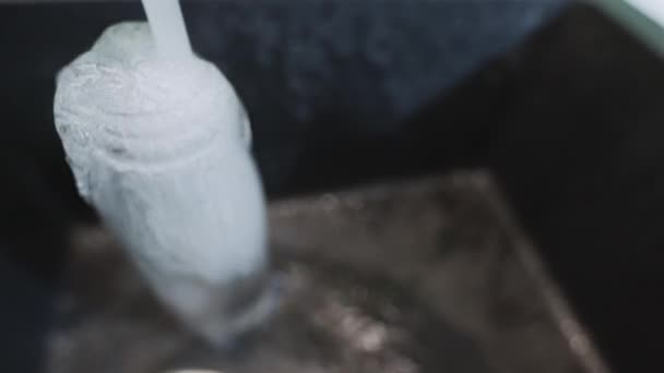 Clean water goes to waste while overfilling bottle — Stock Video