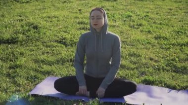 Avrupalı görünümlü genç bir kız gözleri kapalı esnemeyi öğrenir. Açık hava meditasyon eğitimi kavramı.