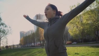 Genç bir kız, güneşli bir günde parkta, temiz havada zıplayarak krikoya biner..