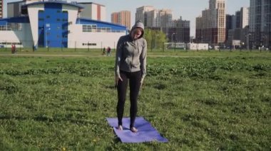 Avrupalı görünümlü genç bir kız yoga egzersizi yapmayı öğrenirken düşer. Açık hava eğitimi kavramı.