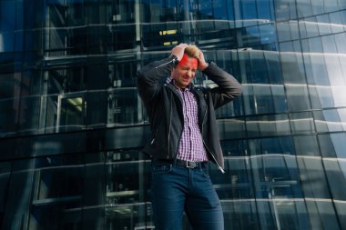 Genç bir adam ayağa kalkıp başını tutar. Kırmızı ile işaretlenmiş migren hastalığı kavramı..