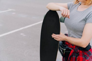 Genç bir kaykaycı kızın uzun kaykaylı bir resmini. Spor, eğlence ve hobi kavramı..