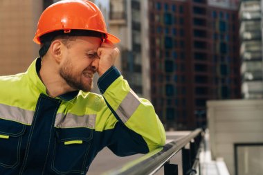 Spastel genç bir adam, yakın plan kasklı, şokta, başını tutuyor. İnsanların hayatını kurtarma kavramı..