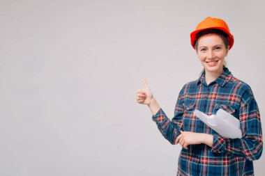 Neşeli inşaatçı iyi bir ruh hali içinde ileriye bakıyor. Yeni binanın serin ve başarılı tamamlanmasına başparmak işareti