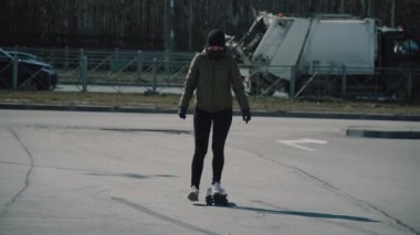 Otoparkta karantina kemeriyle kaykay süren beyaz bir kız, koronavirüs..