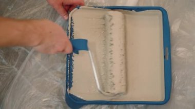 Eller duvarı tamir rulosuyla boyar. 4 km 'lik atış.