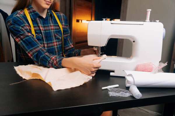 Швея вставляет ткань под иголку в швейную машинку, чтобы сделать эскиз будущего платья.
.