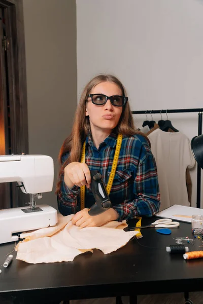 The seamstresses taylor plays 3D glasses in the video console. The concept of a break from a holiday while working a small business.