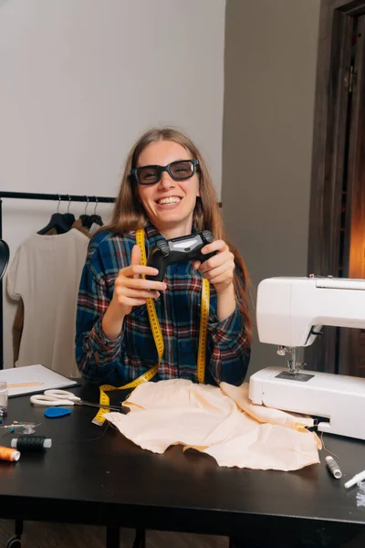 The seamstresses taylor plays 3D glasses in the video console. The concept of a break from a holiday while working a small business.