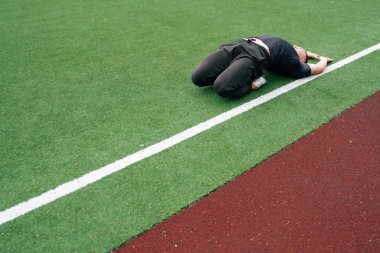 Genç sporcu fitness antrenmanından önce ısınma turuna çıkıyor. Bir yaz günü koşu stadyumunda bacak eklemlerini esnetiyorum.