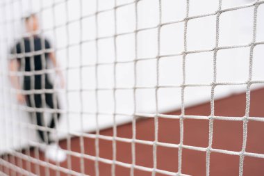 Bulanık futbol arkaplanı. Spor kapısının dışında bir adam duruyor..