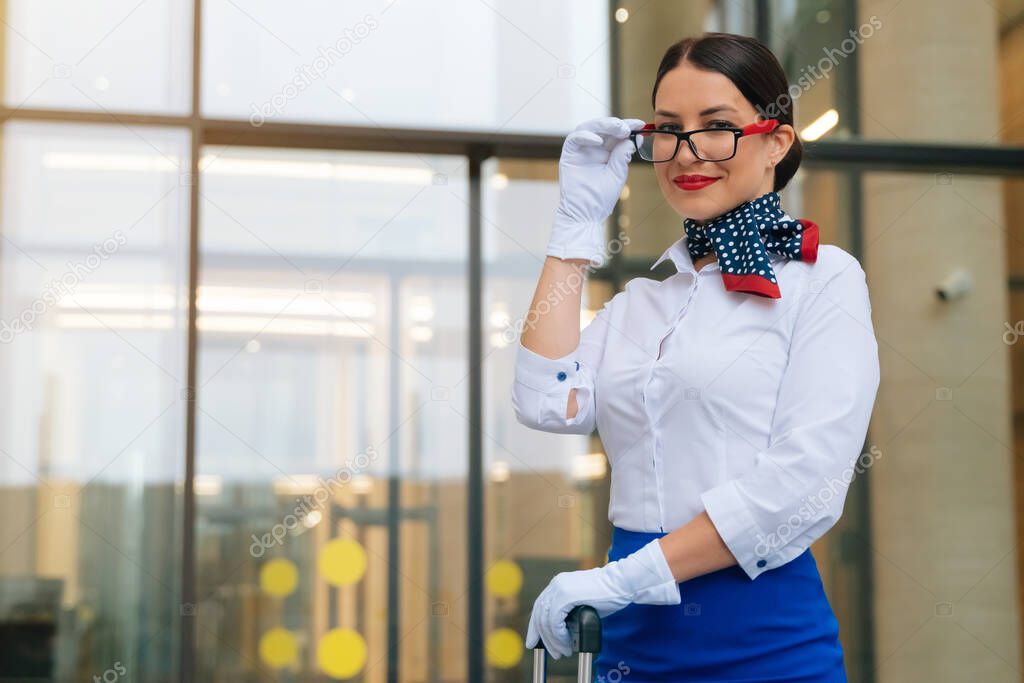 Close-up of the face of a flight attendant in a blue uniform, putting his hand to his head paying tribute to the airport field . High quality photo