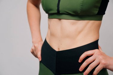 Güzel, süper formda genç bir kadın mükemmel kaslarını gösteriyor. Fitness modeli. Mükemmel ince bir vücut. Stüdyo görüntüsü