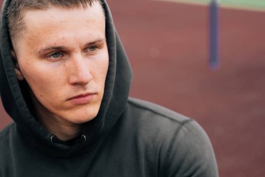 Yan tarafa bakan genç bir Avrupalı vücut geliştiricinin portresi. Spor sahasında bir adama yaklaş.