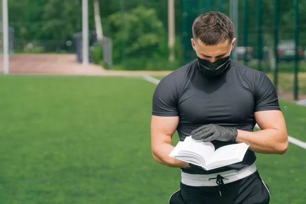 Ung Man Medicinsk Mask Och Engångshandskar Håller Bok Sina Händer — Stockfoto