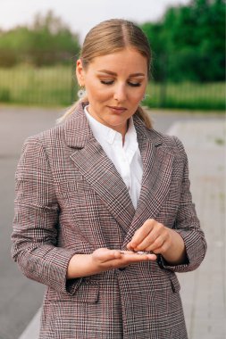 A beautiful successful woman counts small money coins in the hand. The concept of the onset of cashlessness after dismissal. clipart