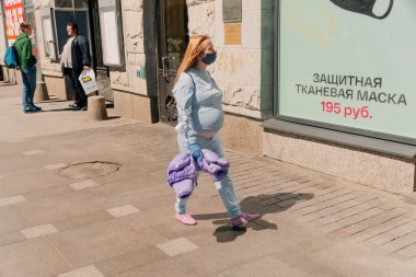 Tıbbi maskeli insanlar şehirde dolaşıyor. Kötü sosyal diyet kavramı. Hamileyim. 8 Haziran 2020 Saint-Petersburg, Rusya