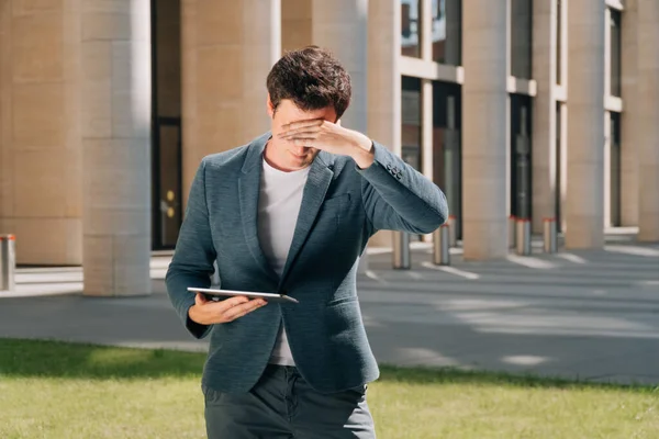 man covered his face with his hand in his palm, surprised apartment specialist, construction in progress concept, engineer in shock