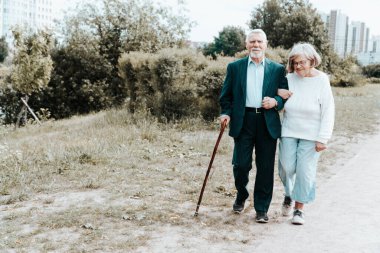 Yetişkin bir Avrupalı çift şehirde dolaşıyor. Temiz havada bir yürüyüş. Büyükbabalar şehirde el ele yürür. Mutlu aile hayatı kavramı.