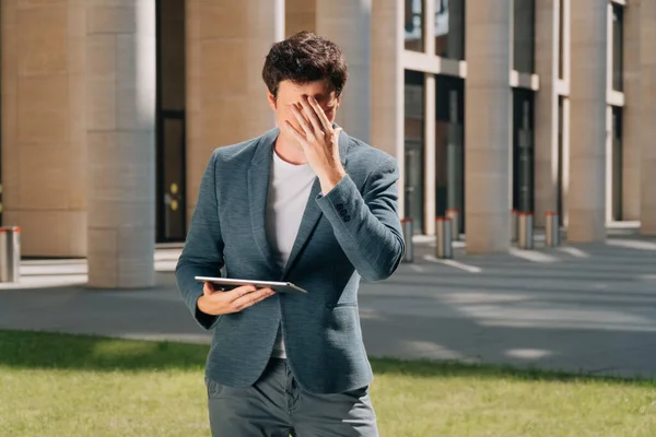 man covered his face with his hand in his palm, surprised apartment specialist, construction in progress concept, engineer in shock