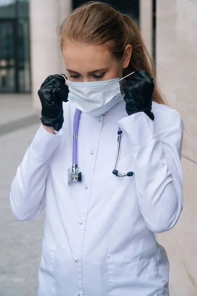 Retrato Una Joven Doctora Poniéndose Una Máscara Médica Con Guantes —  Fotos de Stock