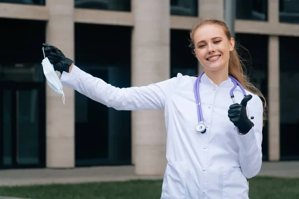 Grappig Meisje Dokter Houdt Een Medisch Masker Een Uitgestrekte Hand — Stockfoto