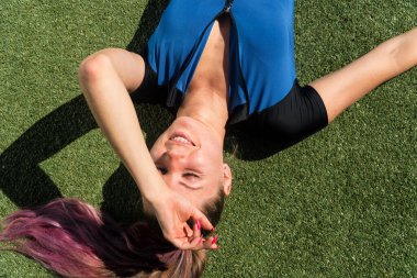 Yorgun genç bir kızı yoga minderinde yüzüstü yatırmak. Güç eğitiminden sonra zayıflık kavramı,