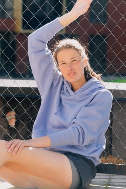 Parkta spor üniformalı şık bir genç kızın portresi. Moda fitness antrenörü konsepti kamerada poz veriyor..