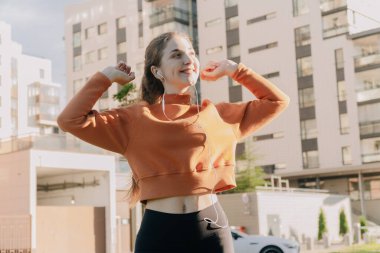 Kız eğitim ve dans sırasında müzik dinliyor. Parktaki temiz hava konsepti.