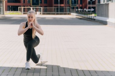 Açık havada spor kıyafetli bir kız, kilo vermek için kalça kaslarını çalıştırıyor. Yoga, günbatımında halı kullanarak fonksiyonel eğitim kavramı.