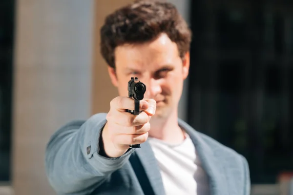 A closeup Portrait of stylish of a man holding a gun directs to the camera. focus on guns