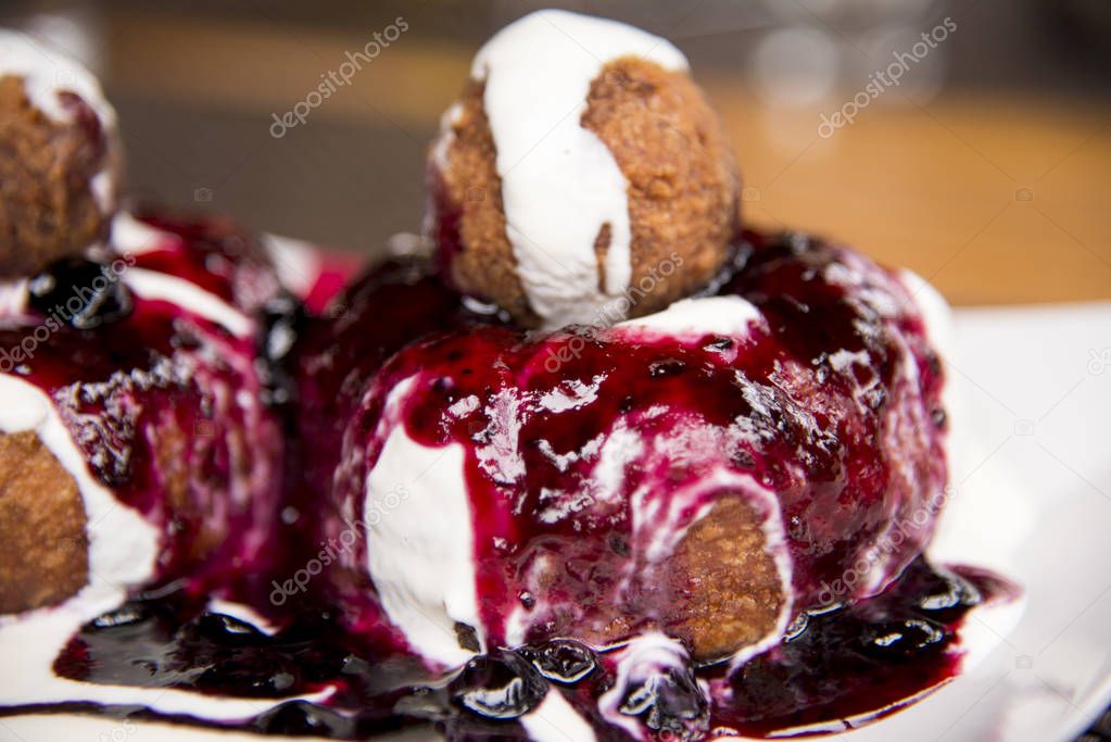 Papanasi - a traditional Romanian dessert. The cake is made from three donuts covered in sour cream and fruits jam