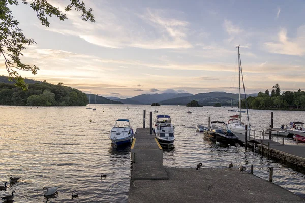 Bowness-on-Windermere, İngiltere - 4 Ağustos 2018: Panoramik güneş batar Lake Windermere içinde olarak Moored Yatlar