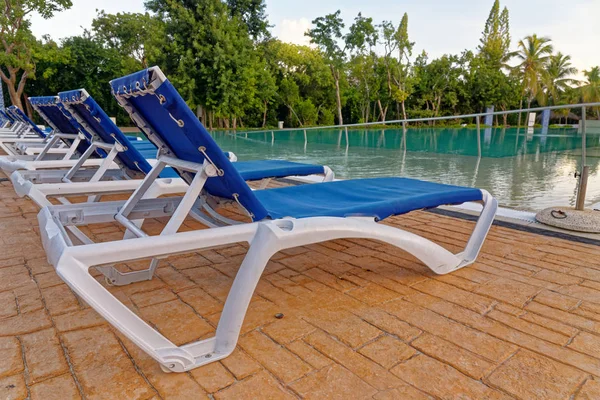 Sillas de playa cerca de piscina — Foto de Stock