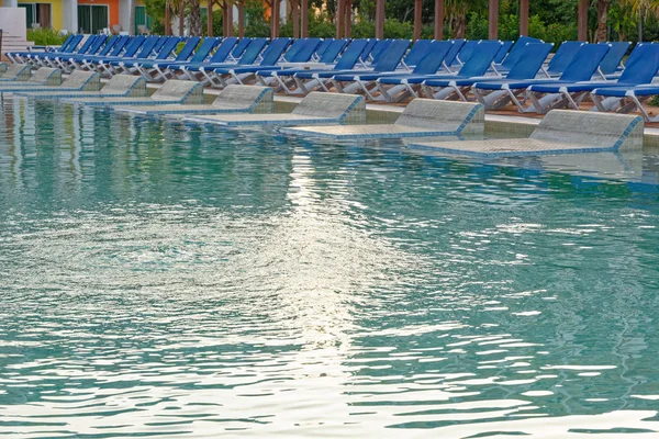 Sillas de playa cerca de piscina — Foto de Stock