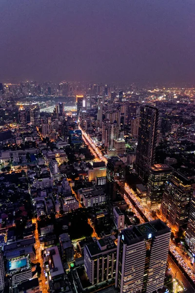 Scenic view of many lit skyscrapers and other buildings in downtown Bangkok, Thailand, from above at night. 22nd of January 2020