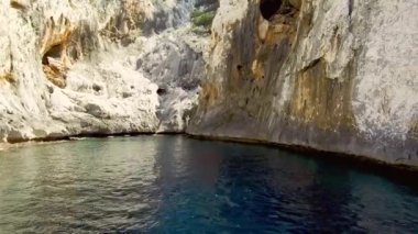 Portu Cuau 'nun dar sarp girişi Capo Monte Santo, Orosei Körfezi, Gennargentu Ulusal Parkı Ogliastra' nın doğu kıyısındaki kireçtaşı kayalarını kesti. 20 Mayıs 2019
