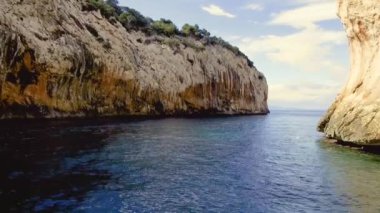 Portu Cuau 'nun dar sarp girişi Capo Monte Santo, Orosei Körfezi, Gennargentu Ulusal Parkı Ogliastra' nın doğu kıyısındaki kireçtaşı kayalarını kesti. 20 Mayıs 2019