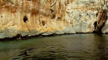 Portu Cuau 'nun dar sarp girişi Capo Monte Santo, Orosei Körfezi, Gennargentu Ulusal Parkı Ogliastra' nın doğu kıyısındaki kireçtaşı kayalarını kesti. 20 Mayıs 2019